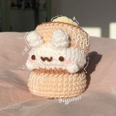 a small crocheted toy is sitting on a bed