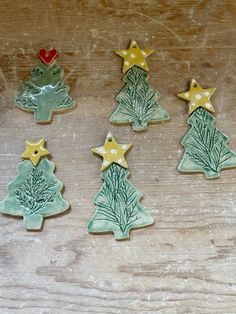 five decorated cookies sitting on top of a wooden table