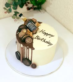 a birthday cake decorated with wine bottles and corks on a white tablecloth next to a potted plant