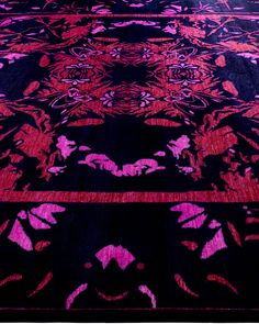 a black and pink rug with designs on it