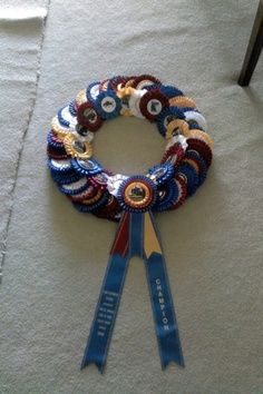 a pair of scissors sitting on top of a white rug next to a blue ribbon