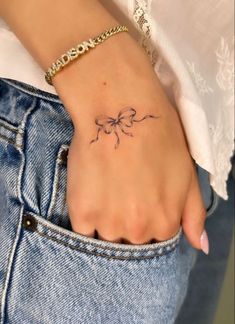 a woman's hand with a small tattoo on it