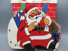 a wooden santa clause standing in front of a brick wall