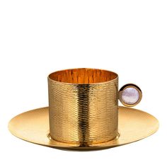 a golden cup and saucer on a gold plate