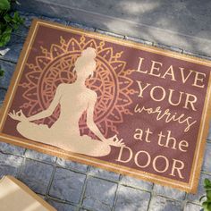 a door mat that says leave your worry at the door with a woman doing yoga