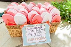 a basket filled with pink and white flip flops next to a sign that says, a you dance if you don't know anything