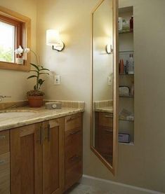 a bathroom with wooden cabinets and marble counter tops