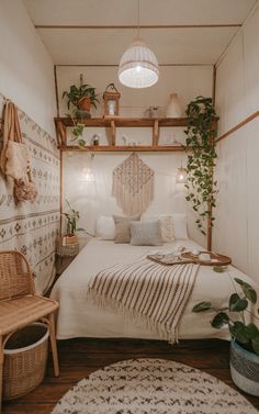 a small bedroom with a bed and plants on the shelves above it, along with a wicker chair