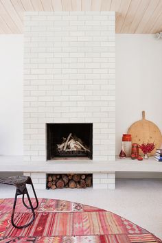 a living room with a fire place and rugs on the floor in front of it