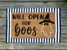 a door mat that says will open for boos on it with a witch's hat