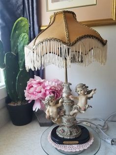 a lamp that is sitting on top of a table next to a potted plant