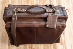 Fly in style next time you take a business trip or vacation with our limited edition brown Leather Flight Bag. This leather bag is finely handcrafted from the highest quality American Bison hides and 100% Made in USA. Any artisan that plays a part in handcrafting your flight bag adds their initials inside, making each flight bag unique. Each handmade vintage leather flight bag fits perfectly in an overhead compartment of an airplane so you can travel quick and easy with this carry on bag. Not on Travel Bag In Distressed Brown Oiled Leather, Distressed Brown Leather Travel Bag, Vintage Oiled Leather Travel Bag, Western Style Hand-tooled Travel Bag, Vintage Brown Leather-handled Travel Bag, Flight Bag, Leather Working Projects, Bison Leather, American Bison