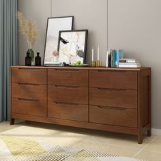 a large wooden dresser with pictures and candles on it's top shelf next to a window