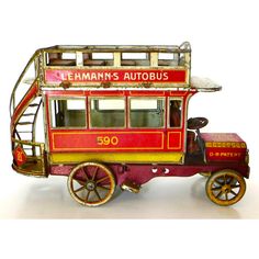 an old fashioned red and yellow toy bus