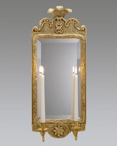 a mirror with two candles in front of it