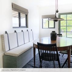 a dining room table and bench in front of a window