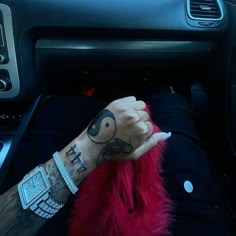 a person with tattoos on their arm sitting in a car