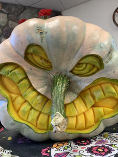 a white pumpkin with an odd face made out of it's leaves and vegetables