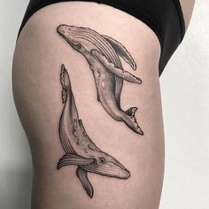 a woman's thigh with two whale tattoos on it