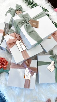 several wrapped gift boxes with ribbons and tags on them