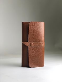 a brown leather wallet sitting on top of a white table