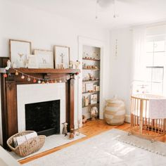 a living room filled with furniture and a fire place next to a baby crib