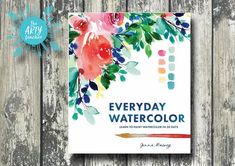 the book cover for everyday watercolor is displayed on a wooden background with an arrow