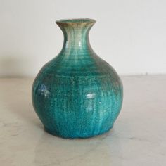 a green vase sitting on top of a table