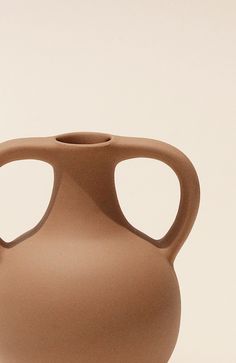 a brown vase sitting on top of a table