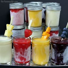 several jars filled with different types of desserts and fruit on top of each other