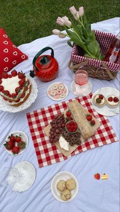 a table topped with lots of cakes and desserts on top of a checkered cloth