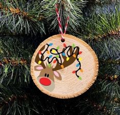 a wooden ornament hanging from a tree with lights and reindeer's head on it