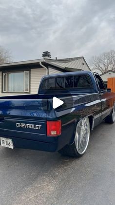 a blue pick up truck parked in front of a house