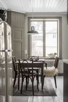 a dining room table and chairs in front of a window