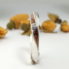 a silver ring sitting on top of yellow flowers