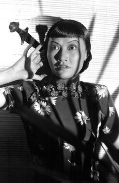 a black and white photo of a woman holding a hair dryer