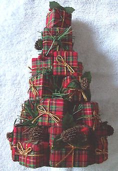 a small christmas tree made out of plaid wrapping paper with pine cones and evergreens