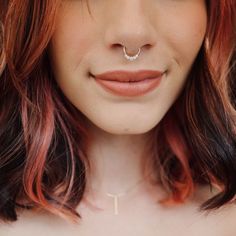 a woman with pink hair and piercings on her nose