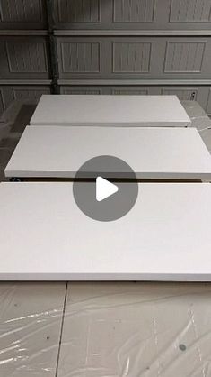 two white boxes sitting on top of each other in the middle of a room with plastic covering them