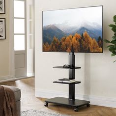 a flat screen tv sitting on top of a stand in front of a wall mounted television