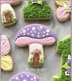 decorated cookies are arranged in the shape of trees and mushrooms, with grass growing on them