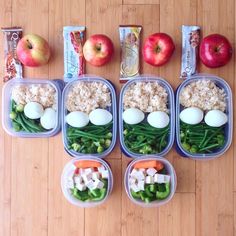 four plastic containers filled with food sitting on top of a wooden floor next to an apple