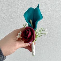 a person is holding a flower in their hand