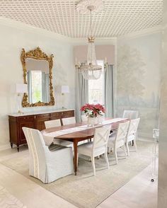 a dining room table with chairs and a chandelier hanging from the ceiling above it