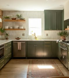 a kitchen with green cabinets and white counter tops, an area rug on the floor