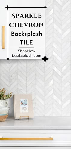 a white kitchen counter with gold accents and herringbone backsplash tile on the wall