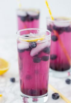 two glasses filled with blueberry lemonade and ice