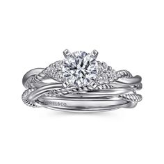 a white gold engagement ring set with an oval diamond center and twisted shants on the band