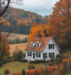 a white house surrounded by autumn foliage and trees