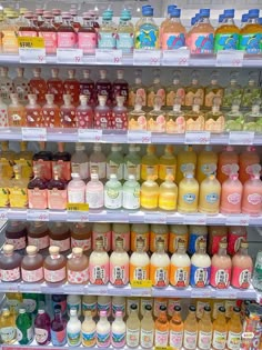 many different types of juices are on display in a store shelf, and one is full of them